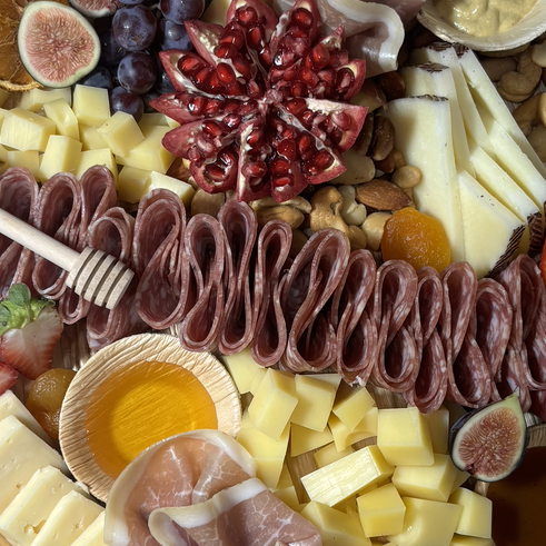 Charcuterie boards near me A colorful assortment of meats, cheeses, fruits, nuts, and honey.